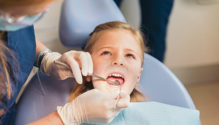 Dentists with a patient during a dental intervention to girl. Dentist  Concept